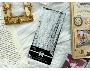 Detailed close-up of white PET lace stickers with vintage floral patterns and silk texture