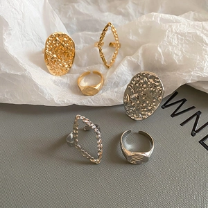 Close-up of six-piece textured metal ring set in gold and silver with geometric patterns