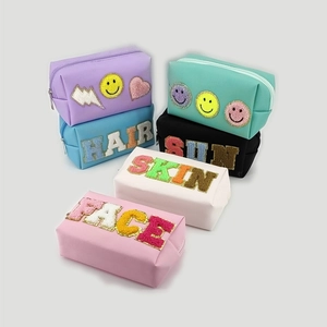 Detailed view of colorful PU leather makeup bags with chenille letter patches and zipper