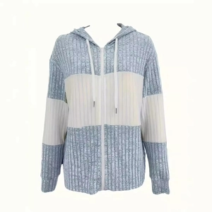 Detail van de lichtblauwe en witte gebreide hoodie met ribpatroon en patchwork