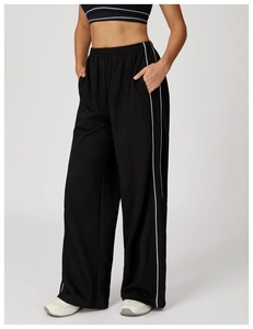 Détail du pantalon de jogging large avec bandes latérales, taille élastique et texture
