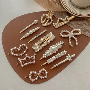 Elegant gold pearl hair clips set with heart and butterfly designs on brown leather base