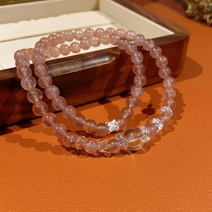 Detailed close-up of double-layer strawberry quartz beads with silver floral accents
