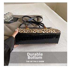 Detail showing the wear-resistant glossy crocodile pattern base of the leopard print bag