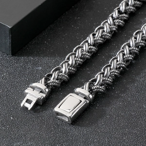 Close-up of a chunky silver braided dragon bone chain with a square metal clasp