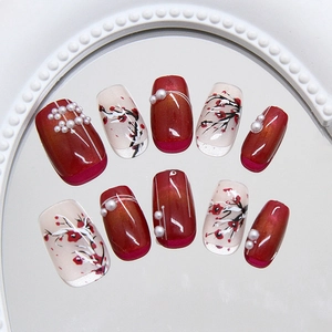 Handmade red cat eye press-on nails with plum blossom art and elegant pearl accents