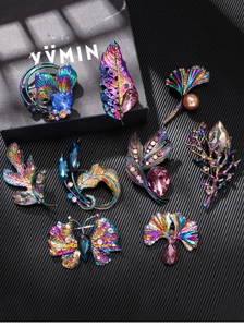 Detailed macro view of colorful plated butterfly and leaf brooches with rhinestones