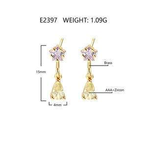 Macro detail of 18k gold plated drop earrings with pink star and yellow pear cubic zirconia