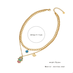 Close-up of gold stainless steel layered necklace with Hamsa hand and evil eye charms