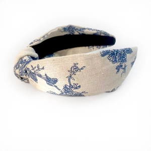 Detail view of the beige linen knotted headband with blue floral and bird prints