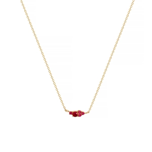 Detail of a thin gold chain with a red gemstone cluster pendant on white background
