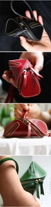 Detail view of leather key pouch featuring durable white stitching and double zippers