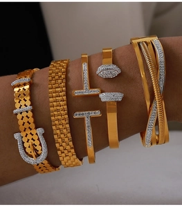 Detailed stack of gold titanium steel bangles with geometric pavé diamond accents