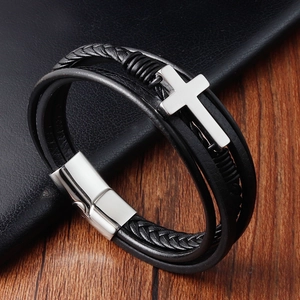 Detail of multi-layer black braided leather bracelet with silver cross and magnetic clasp
