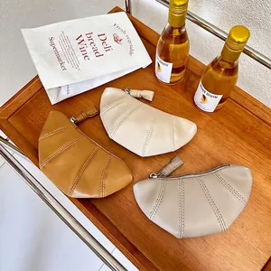 Petit sac croissant minimaliste en cuir en couleurs caramel, blanc et gris chiné