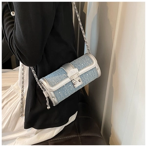 Close-up of a blue sequined cylinder bag with silver leather trim and chain strap