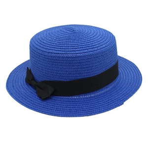 Detail of navy blue straw boater hat with fine weaving and black grosgrain ribbon bow