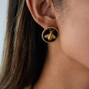 Vue détaillée des boucles d'oreilles rondes abeille en acier doré 18 carats sur le mannequin