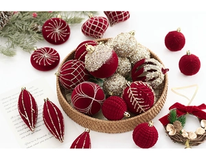 Gros plan de boules de Noël floquées rouge foncé et d'ornements dorés pailletés