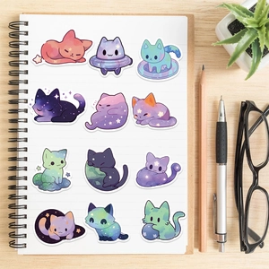Starry sky cat stickers displayed on an open white notebook with office supplies and plant