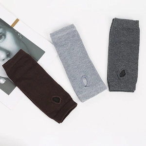 Close-up of three striped knitted arm warmers in grey and brown with thumb holes