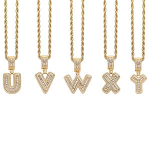 Macro detail of iced-out gold alphabet pendants U-Y with rectangular zircon inlays