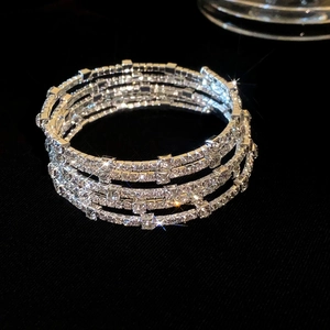 Detailweergave van zilveren meerlaagse spiraalarmband met fonkelende strass-steentjes