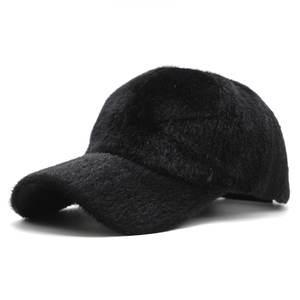 Close-up of black faux fur baseball cap showing thick plush texture and curved brim
