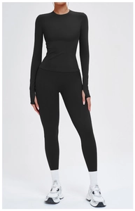 Detail eines schwarzen nahtlosen Yoga-Langarmshirts mit Daumenlöchern und Leggings