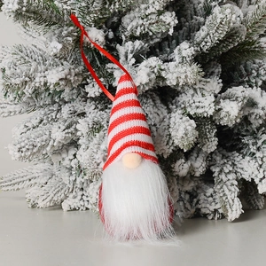 Detail of knitted Christmas gnome ornament with red striped hat and long white beard