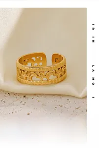 Detail of 18K gold plated V-shape ring with cutout star and moon patterns on silk fabric