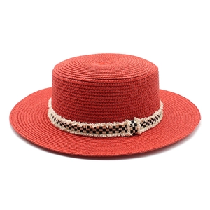Vue de dessus du chapeau de paille rouge avec ruban à carreaux noir et blanc à franges