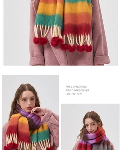 Detail of rainbow gradient winter scarf with fluffy red pom-poms and long fringe accents