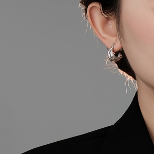 Close-up of irregular silver foil texture earring showing detailed metallic lava finish