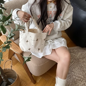 Corduroy tote bag featuring bear patterns shown in a lifestyle casual setting