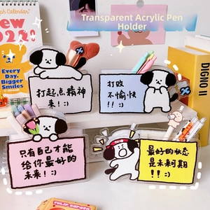 Close-up of four acrylic pen holders with cartoon dog motifs and motivational quotes