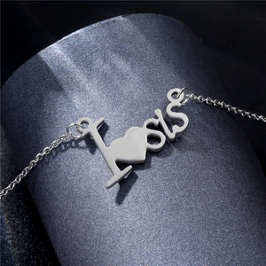 Collier en acier inoxydable argenté avec pendentif cœur LOVE sur fond texturé sombre