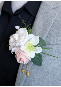 Détail d'une boutonnière faite main rose et blanche sur le revers d'un costume gris