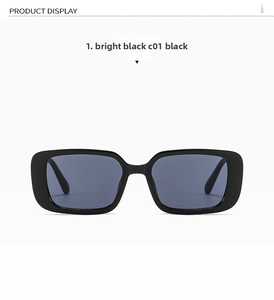 Detail view of glossy black rectangular sunglasses with dark grey lenses in high resolution
