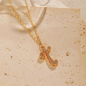 Close-up of 18K gold plated necklace with a sparkling T-letter pendant set with zircons