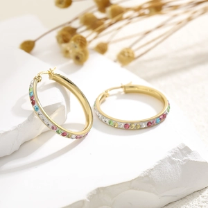 Close-up of golden hoop earrings with colorful crystals and 925 silver stamp details