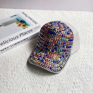 Detailed macro shot of colorful rhinestones and pearls on a light gray baseball cap