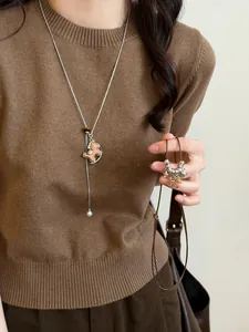 Detailed view of vintage wooden rocking horse pendant with pearls on a silver chain