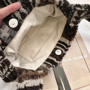 Detail of leopard print plush bag interior featuring canvas lining and magnetic snap closure