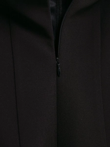 Detailed view of the invisible zipper closure and smooth woven fabric on black dress