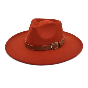 Détail du chapeau en laine orange avec ceinture en cuir marron et boucle en métal