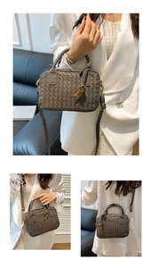 Detail of grey woven Boston bag featuring gold-tone hardware and detachable strap