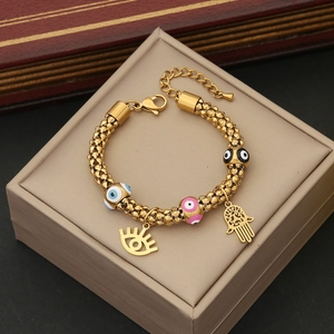 Macro shot of gold Evil Eye bracelet with Fatima hand charms on a jewelry box
