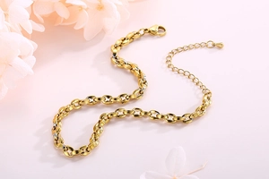Detail der goldenen Metall-Fußkette mit Karabinerverschluss und Verlängerung auf Rosa