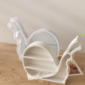Modern snail-shaped resin storage organizers with tiered compartments on a wooden table